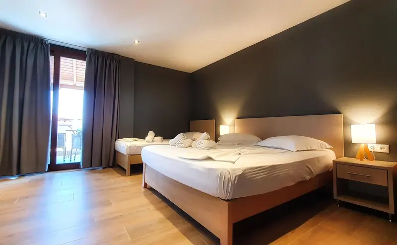 Une chambre lumineuse avec un grand lit et un accès à une terrasse.