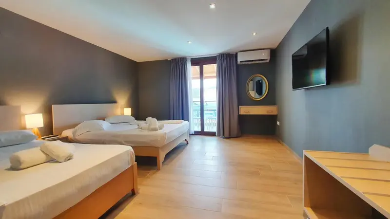 Une chambre lumineuse avec deux lits et un accès à un balcon.