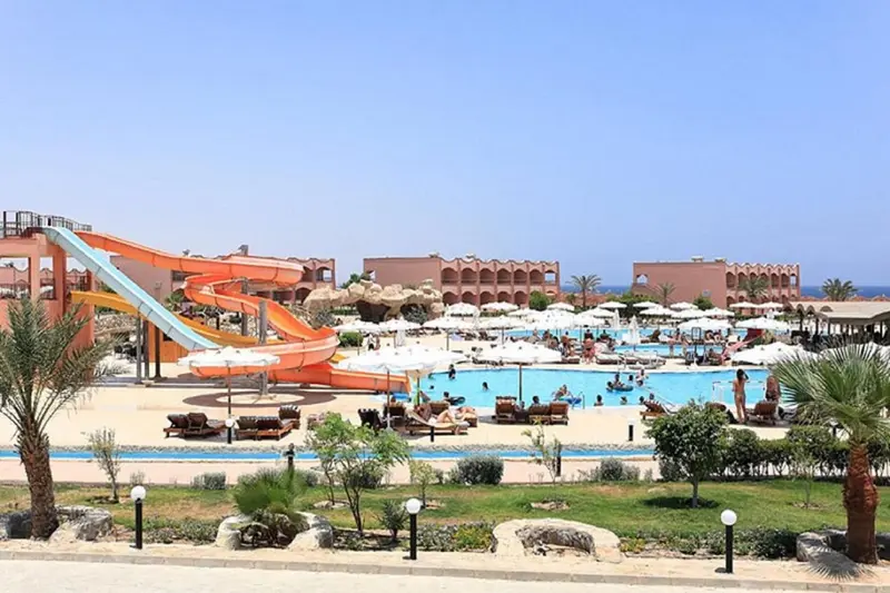 Vue aérienne d'un complexe hôtelier avec piscine et toboggans aquatiques.