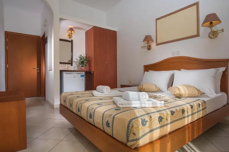 Une chambre lumineuse avec un grand lit et un meuble de rangement.