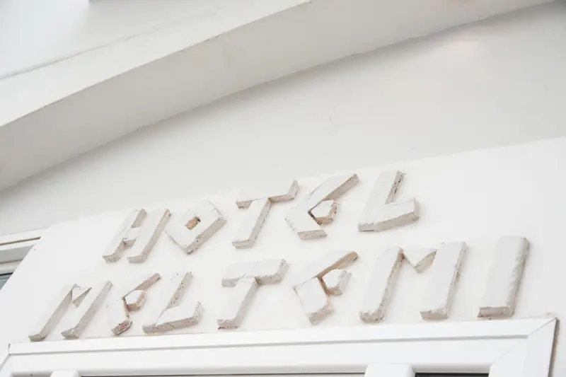 Façade d'un bâtiment avec le nom de l'hôtel en relief.