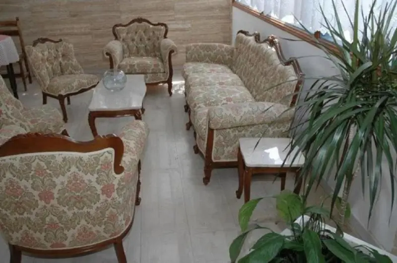 Un salon avec des fauteuils et des tables basses.