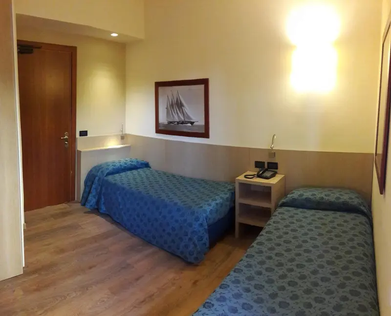 Une chambre avec deux lits simples et une décoration sobre.