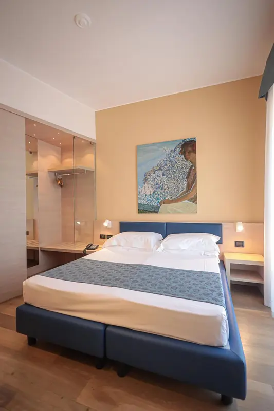 Une chambre d'hôtel lumineuse avec un grand lit et une décoration murale.