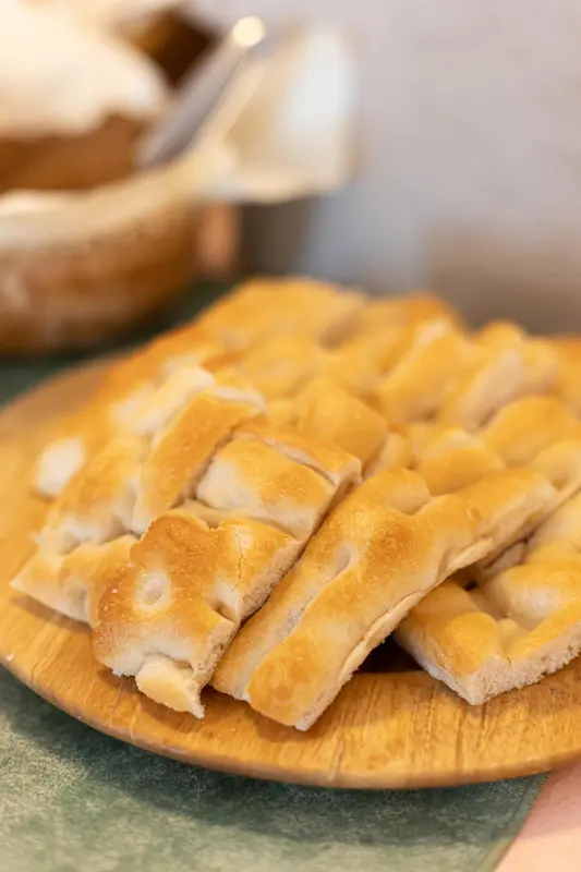 Assortiment de pains et de viennoiseries présentés sur un plateau en bois.