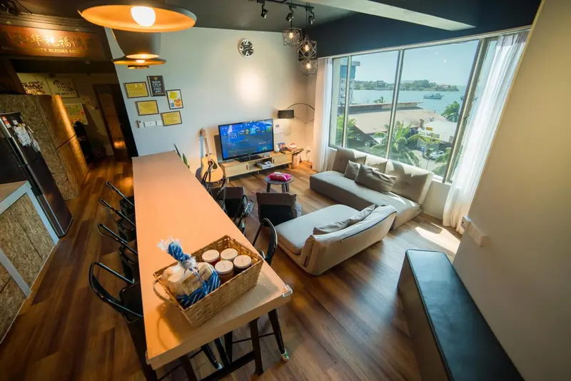 Espace de vie lumineux avec canapés, table basse et vue sur la mer.