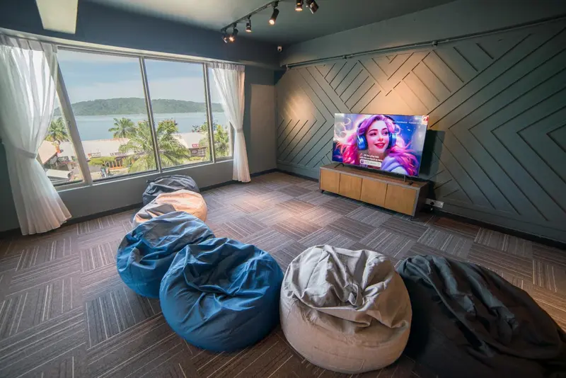 Espace de détente intérieur avec canapés-sac et vue sur la mer.