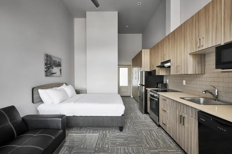 Une chambre avec un coin cuisine et un canapé.