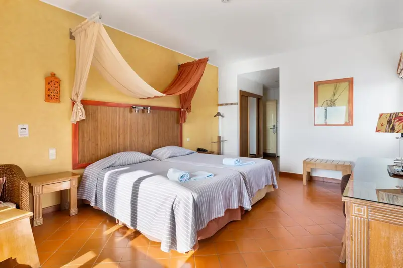 Une chambre lumineuse avec un lit à baldaquin et une décoration colorée.