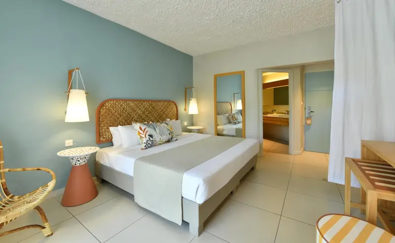 Chambre lumineuse avec un grand lit et une décoration soignée.
