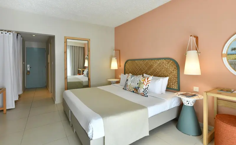 Une chambre lumineuse avec un grand lit et une décoration soignée.