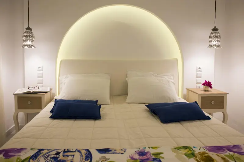 Une chambre lumineuse avec un grand lit recouvert d'une courtepointe.