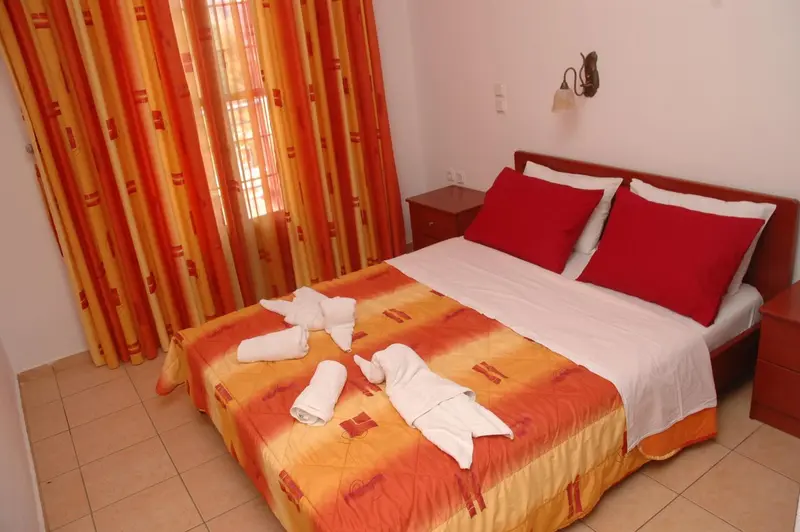 Une chambre avec un lit double et des oreillers rouges.