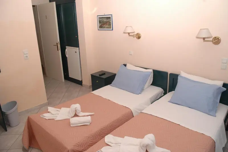 Une chambre avec deux lits simples et des serviettes décoratives.