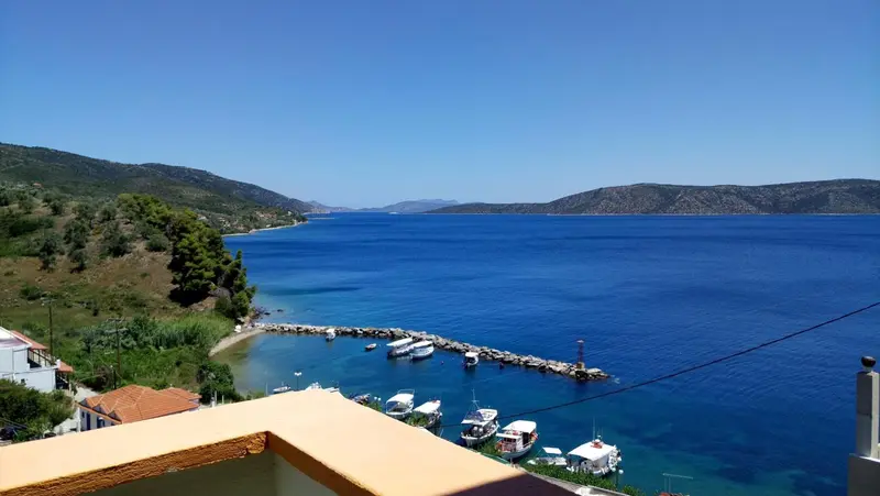 Vue panoramique sur une baie ensoleillée et les collines environnantes.