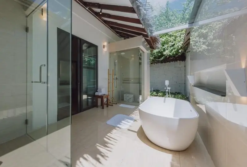 Une salle de bain lumineuse avec baignoire et douche à l'italienne.