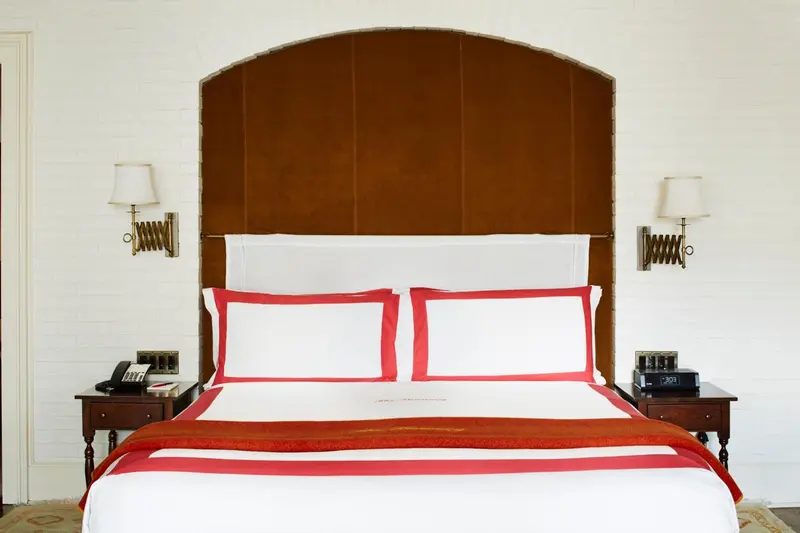 Un lit double avec une couverture rouge et des oreillers blancs dans une chambre.