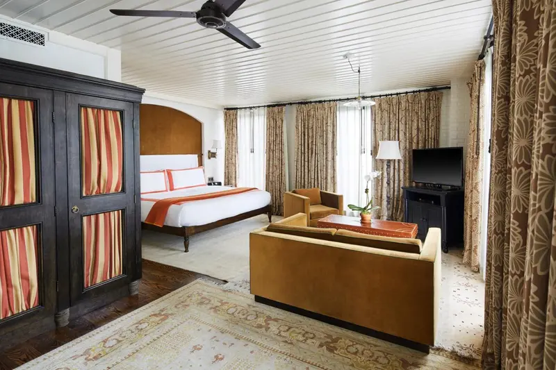 Une chambre lumineuse avec un grand lit et un coin salon.