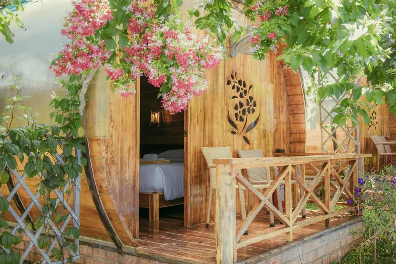 Une terrasse en bois devant une habitation en forme de tonneau.