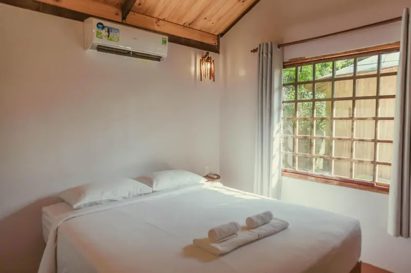 Une chambre lumineuse avec un lit simple et une fenêtre.