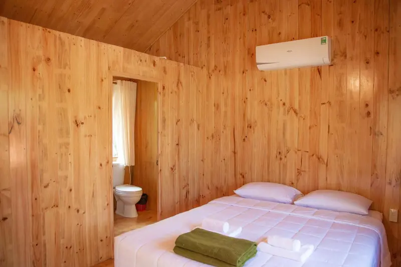 Une chambre lumineuse avec un lit et des toilettes.