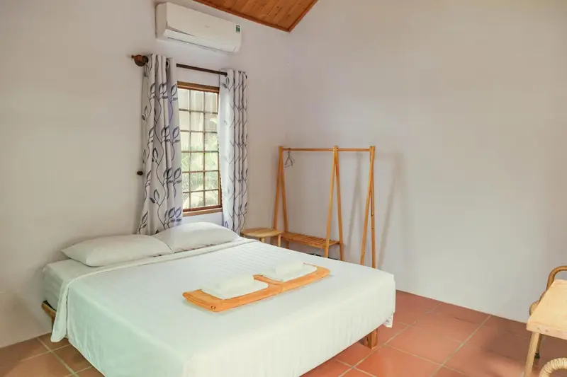 Une chambre lumineuse avec un lit double et une fenêtre.