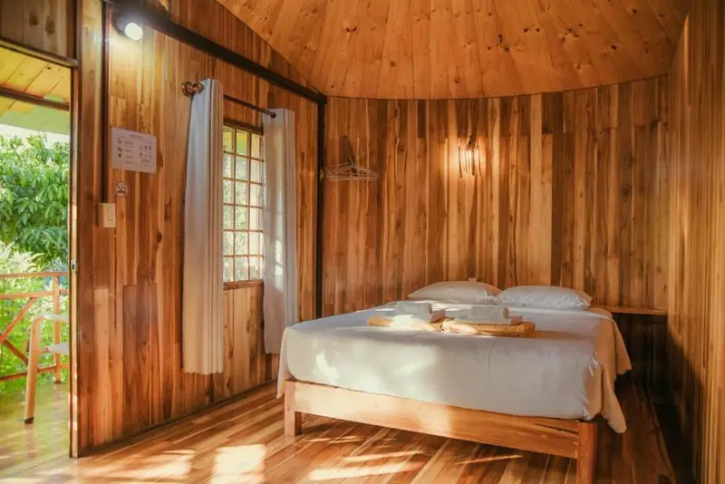 Intérieur chaleureux d'une chambre avec un lit recouvert d'une courtepointe blanche.