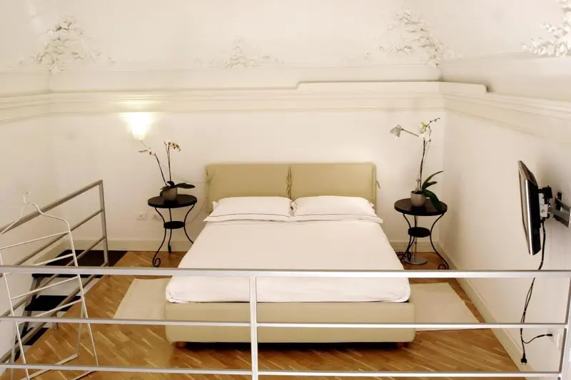 Une chambre mansardée lumineuse avec un lit double et des tables de chevet.