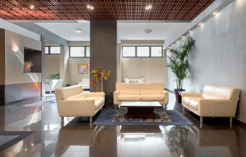 Espace de détente avec canapés et tapis dans un intérieur clair.