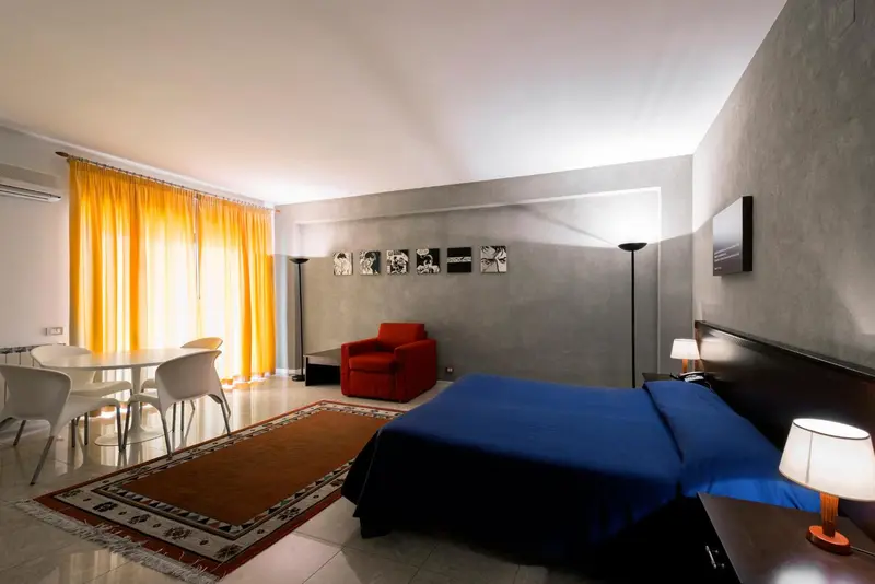 Une chambre lumineuse avec un lit et un coin repas.