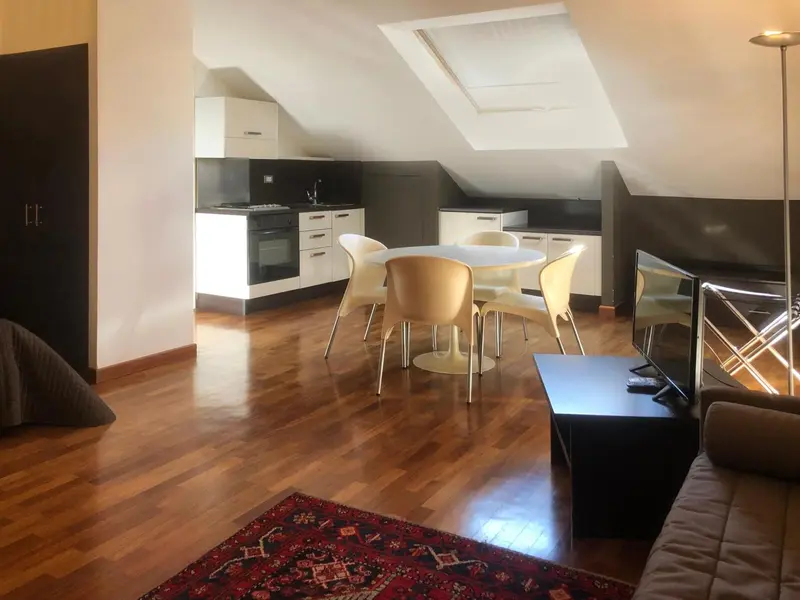 Une cuisine ouverte sur un espace repas avec une table ronde et des chaises.