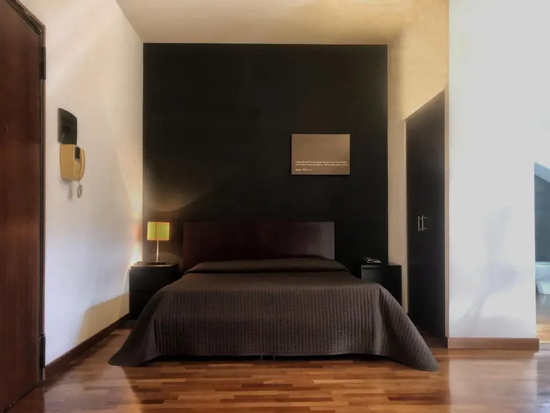 Une chambre avec un lit double et une lampe de chevet.