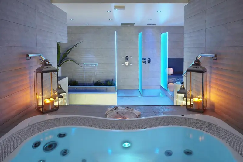 Espace bien-être avec jacuzzi et douches à jets.