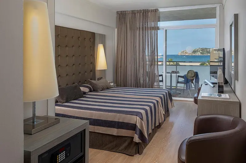 Une chambre lumineuse avec un grand lit et une vue sur la mer.
