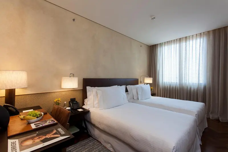 Une chambre d'hôtel lumineuse avec un grand lit et des lampes de chevet.