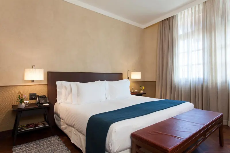 Une chambre lumineuse avec un grand lit et des tables de chevet.