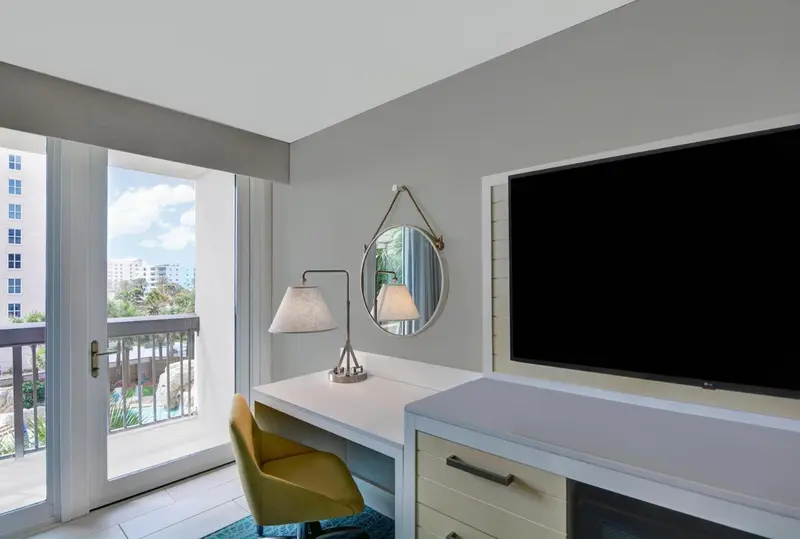 Une chambre lumineuse avec un bureau et une vue sur la mer.