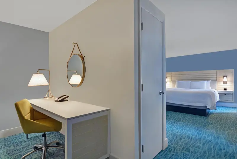 Une chambre lumineuse avec un bureau et un lit.