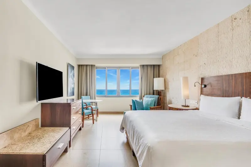 Une chambre lumineuse avec un grand lit et une vue sur la mer.