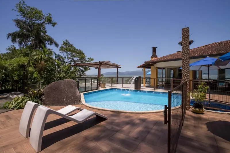 Terrasse avec piscine et mobilier de détente.