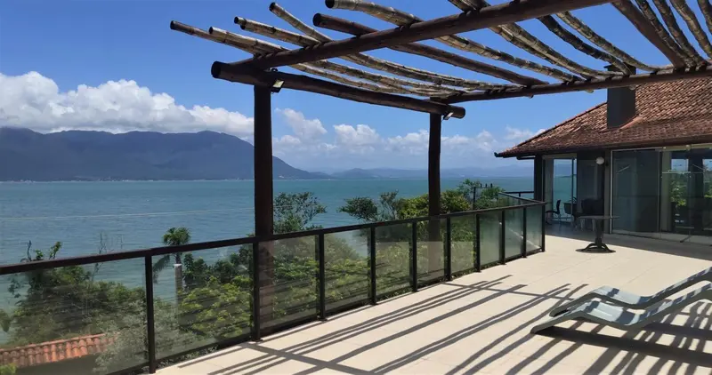 Terrasse ombragée avec vue sur la mer et les montagnes.