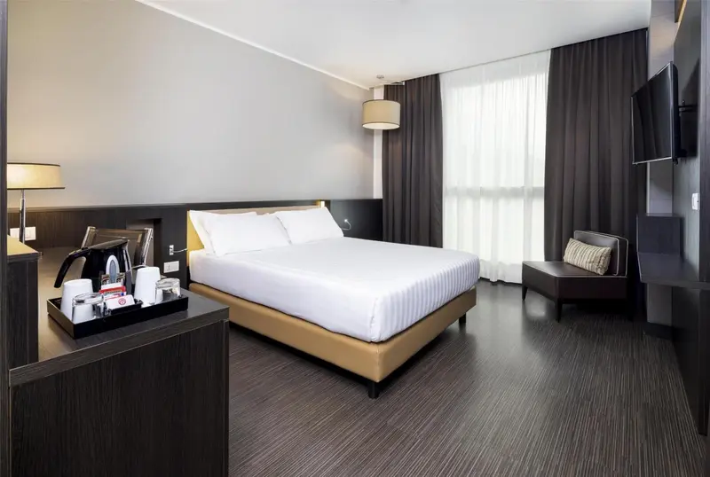 Une chambre moderne avec un grand lit et un coin repos.