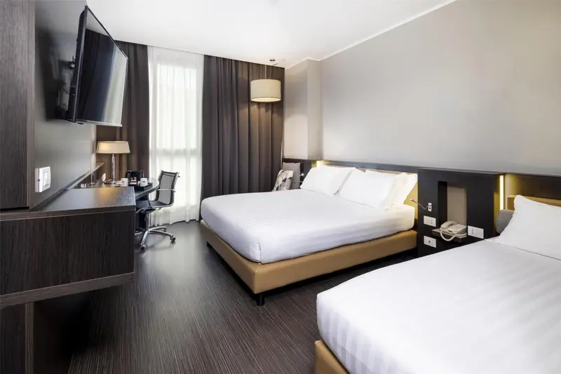 Une chambre d'hôtel moderne avec un grand lit et un bureau.