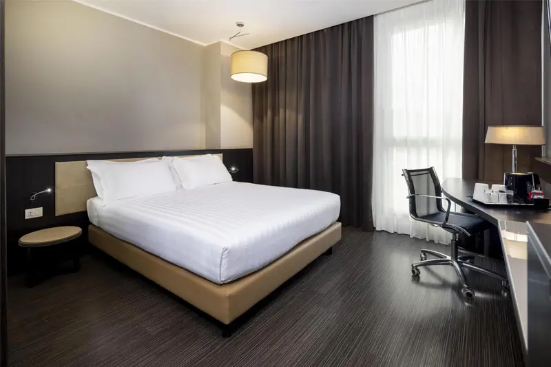 Une chambre d'hôtel moderne avec un grand lit et un bureau.