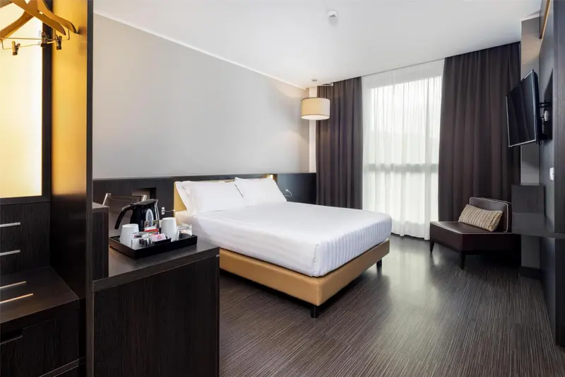 Une chambre d'hôtel moderne avec un grand lit et un coin salon.