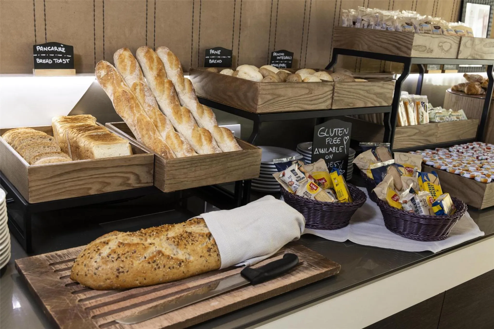 Présentation de viennoiseries et de pains variés sur un buffet.