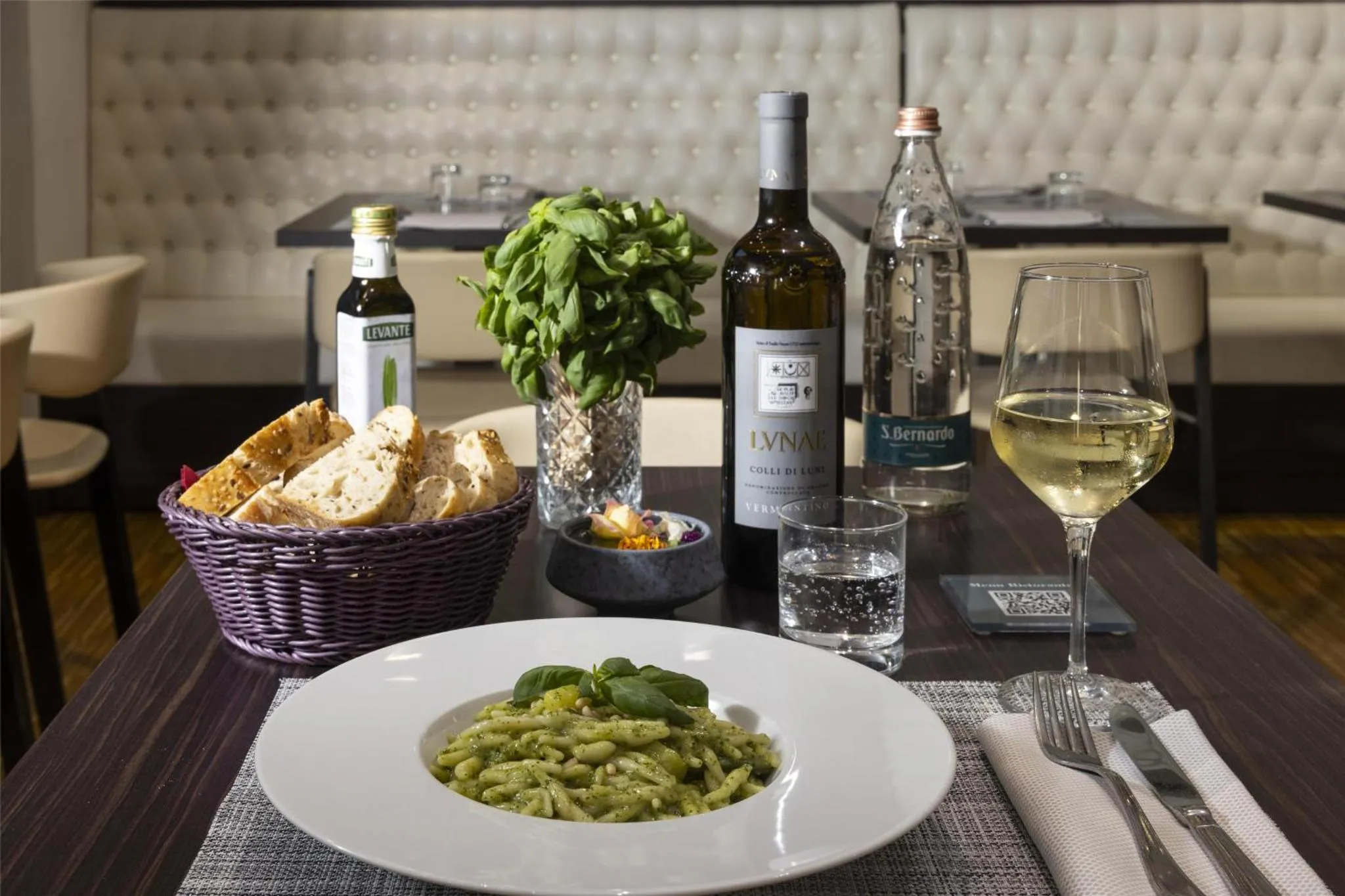 Une table est dressée avec des plats, des bouteilles et des verres.
