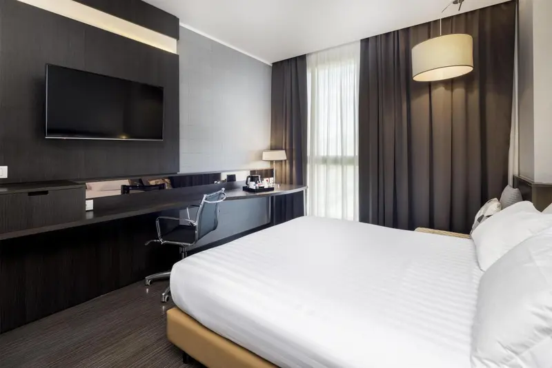 Une chambre moderne avec un grand lit et un bureau.