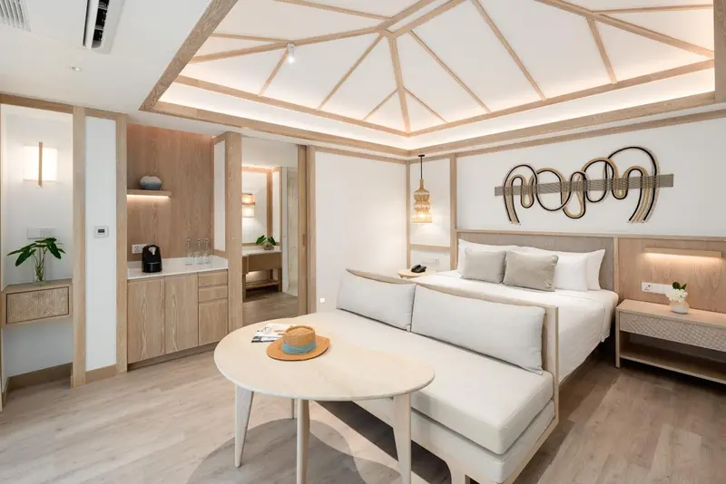 Chambre lumineuse avec un grand lit et un espace détente.