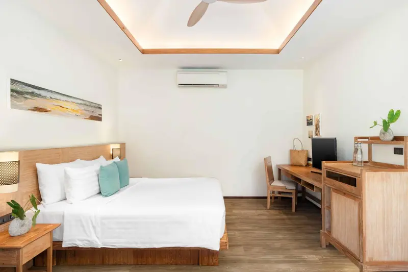 Une chambre lumineuse avec un grand lit et un espace bureau.